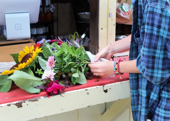 An Employee Bundles Fresh Flowers, Hand Cut by a Customer for 50 Cents Per Stem. Photo Courtesy Nicole Jean Turner.